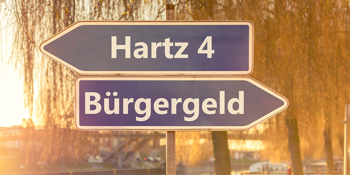 KI generiert: Das Bild zeigt zwei Straßenschilder mit den Aufschriften "Hartz 4" und "Bürgergeld", die in entgegengesetzte Richtungen weisen. Es symbolisiert den Übergang oder die Veränderung von einem sozialen System zum anderen in Deutschland.