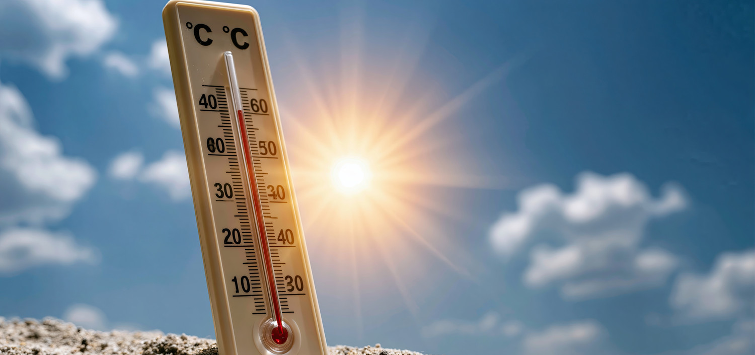 KI generiert: Das Bild zeigt ein Thermometer in der prallen Sonne, das über 30 Grad Celsius anzeigt. Der Himmel ist blau mit einigen Wolken, während die Sonne hell scheint.