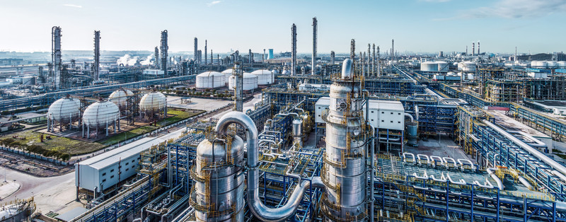 KI generiert: Das Bild zeigt eine große industrielle Anlage mit zahlreichen Rohrleitungen, Tanks und Schornsteinen, die auf eine Raffinerie oder chemische Fabrik hindeuten. Der Fokus liegt auf der komplexen Infrastruktur und den vielseitigen industriellen Strukturen.